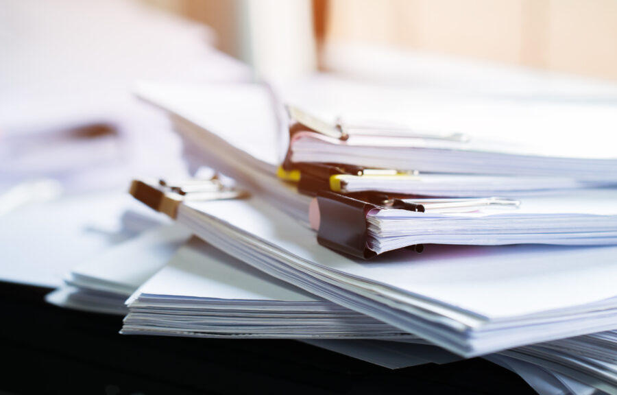 Stack of papers documents in archives files with clip papers on